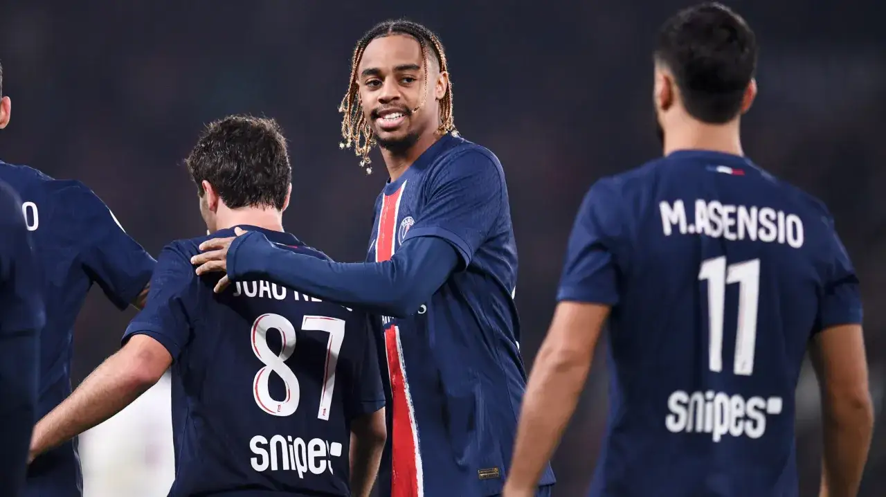 Piłkarze PSG w ciemnych strojach, jeden z nich z warkoczykami, cieszą się po meczu. Ich numery i nazwiska mogą być częścią ligue 1 statystyki.