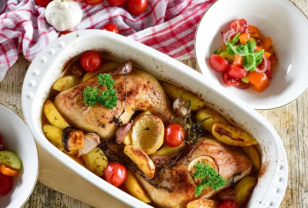 D&eacute;licieuse cuisse de poulet au four, dor&eacute;e et juteuse, accompagn&eacute;e de pommes de terre r&ocirc;ties, tomates cerises et ail.