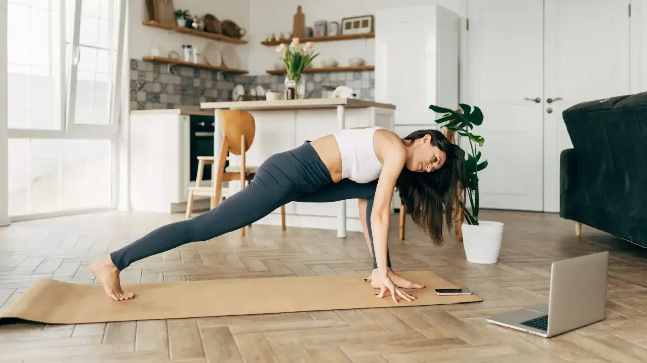 Frau macht Pilates zum Abnehmen zu Hause, gefolgt von einem Online-Kurs.