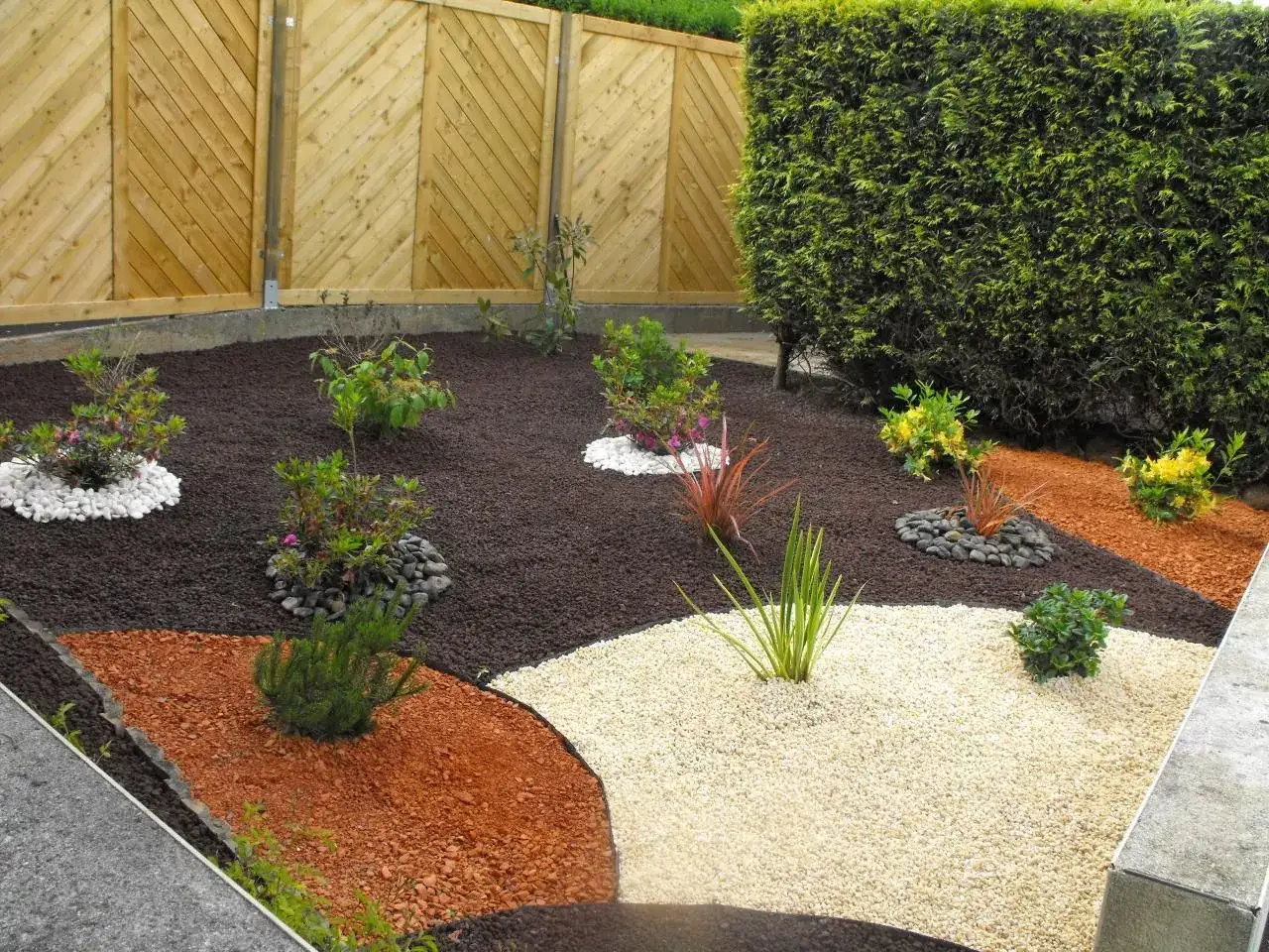 Un jardin moderne avec des graviers de différentes couleurs et des plantes pour créer un massif sans entretien.