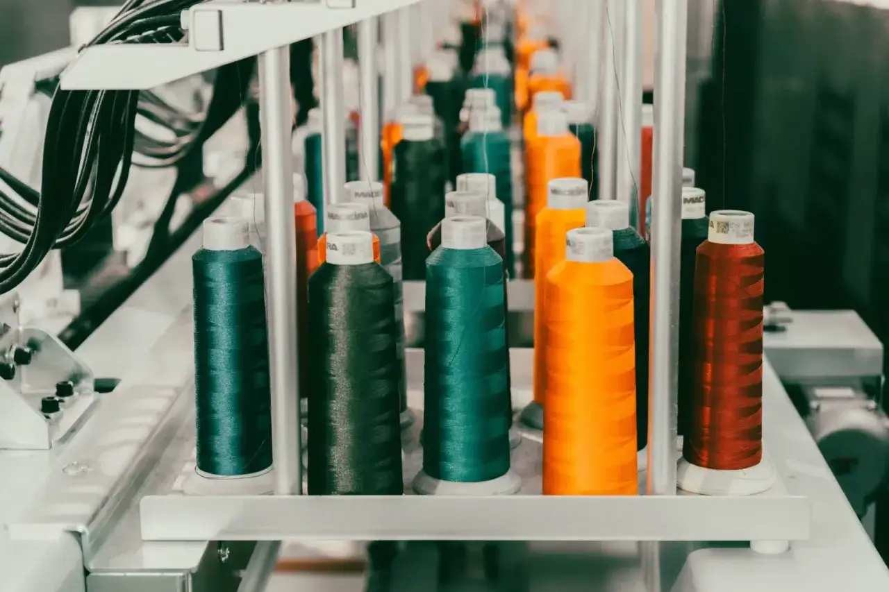Bobines de fil color&eacute;es pr&ecirc;tes pour la broderie sur textile. Vert, orange, rouge, noir, un arc-en-ciel de possibilit&eacute;s cr&eacute;atives.