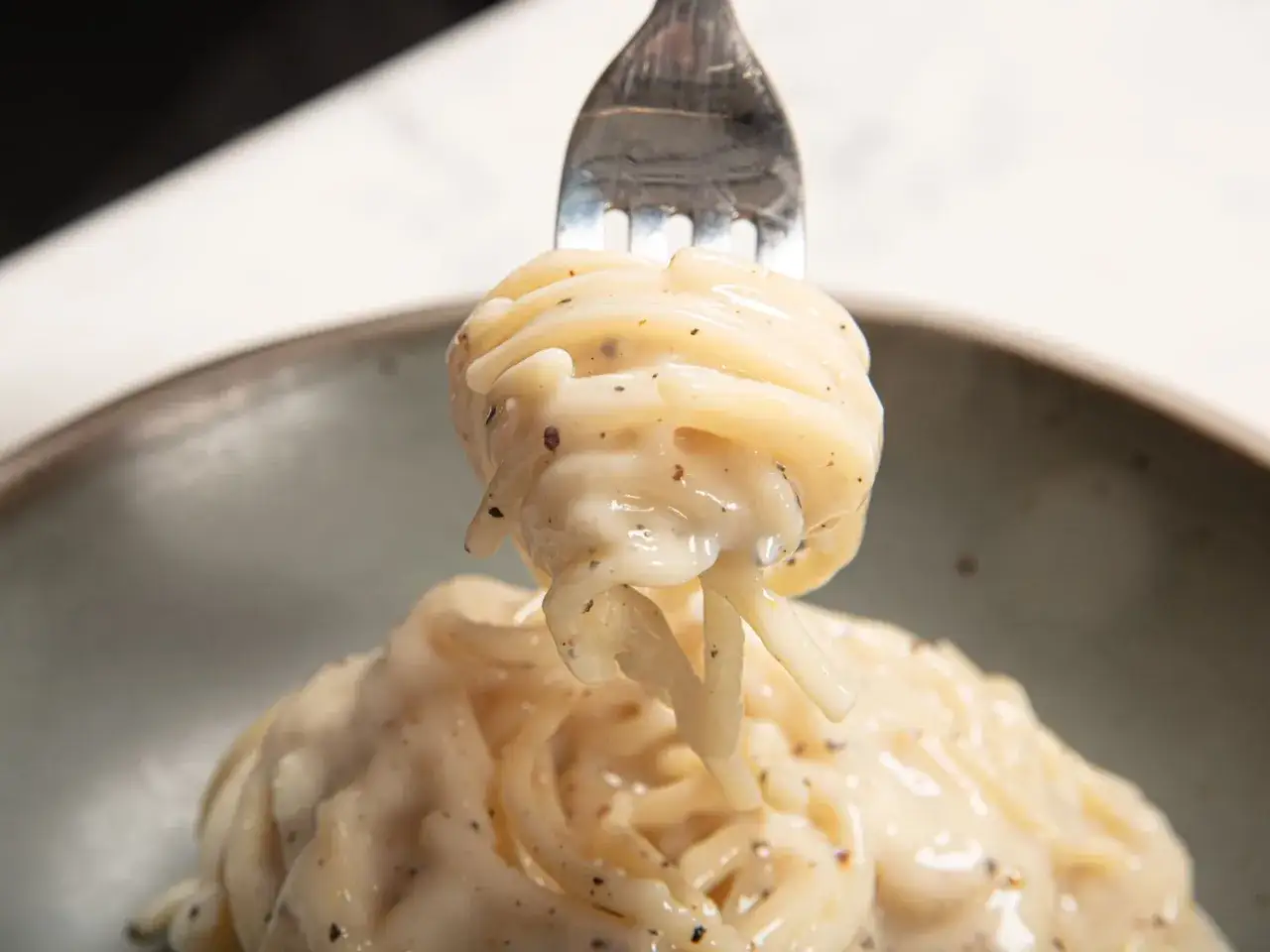 Ein Gabel voll cremiger Spaghetti, perfekt f&uuml;r ein Cacio e Pepe Rezept.