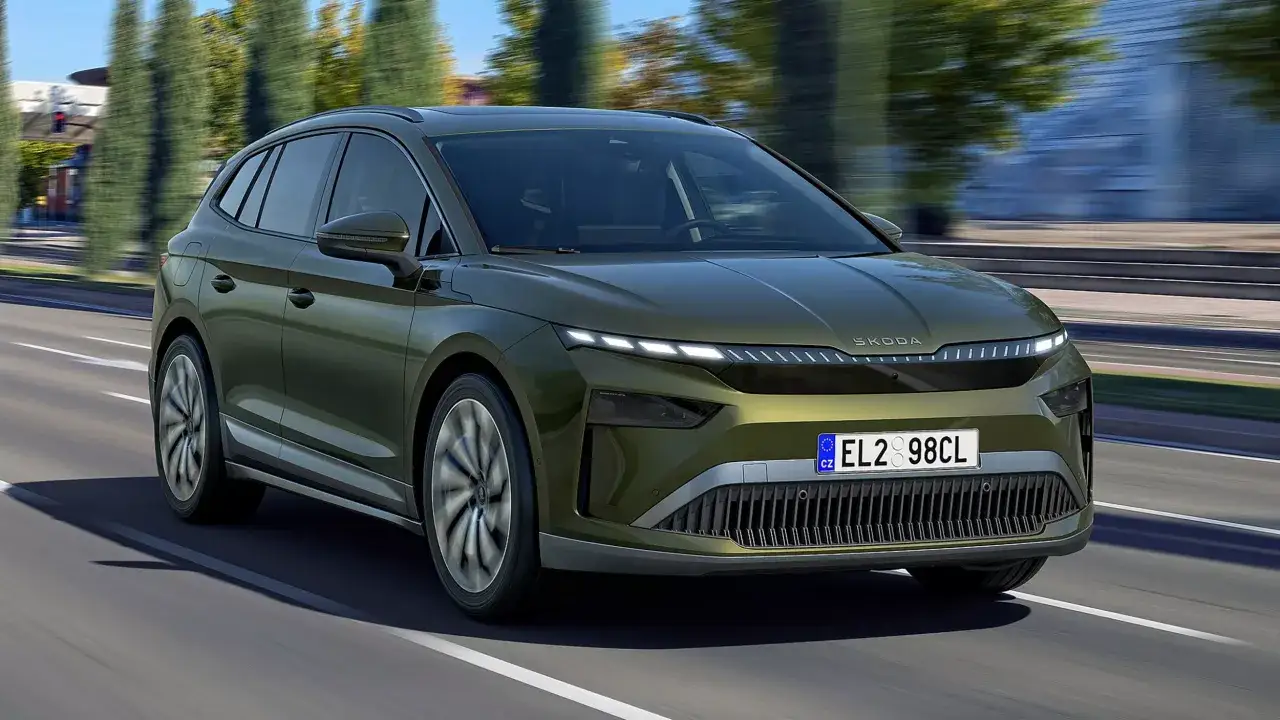 Zielony Skoda Enyaq jedzie po drodze, pokazując swój imponujący zasięg.