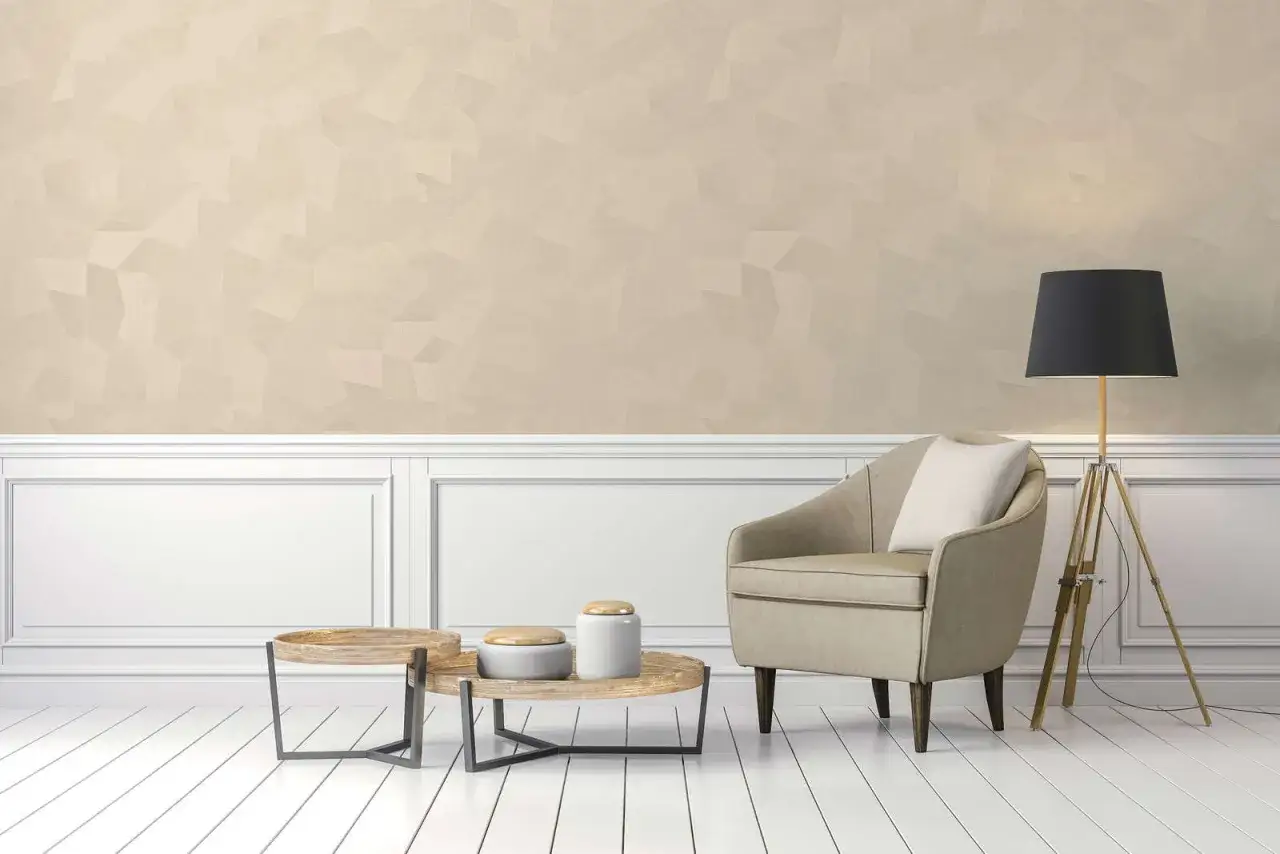Una poltrona beige e tavolini in legno con decorazioni in stile pittura sabbia. Lampada nera su treppiede.