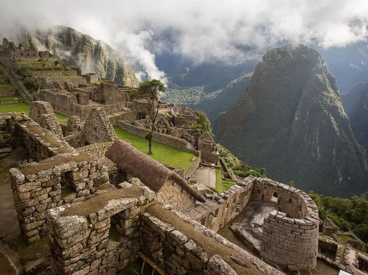 Ruinas de Machu Picchu, con terrazas de piedra y montañas cubiertas de niebla.