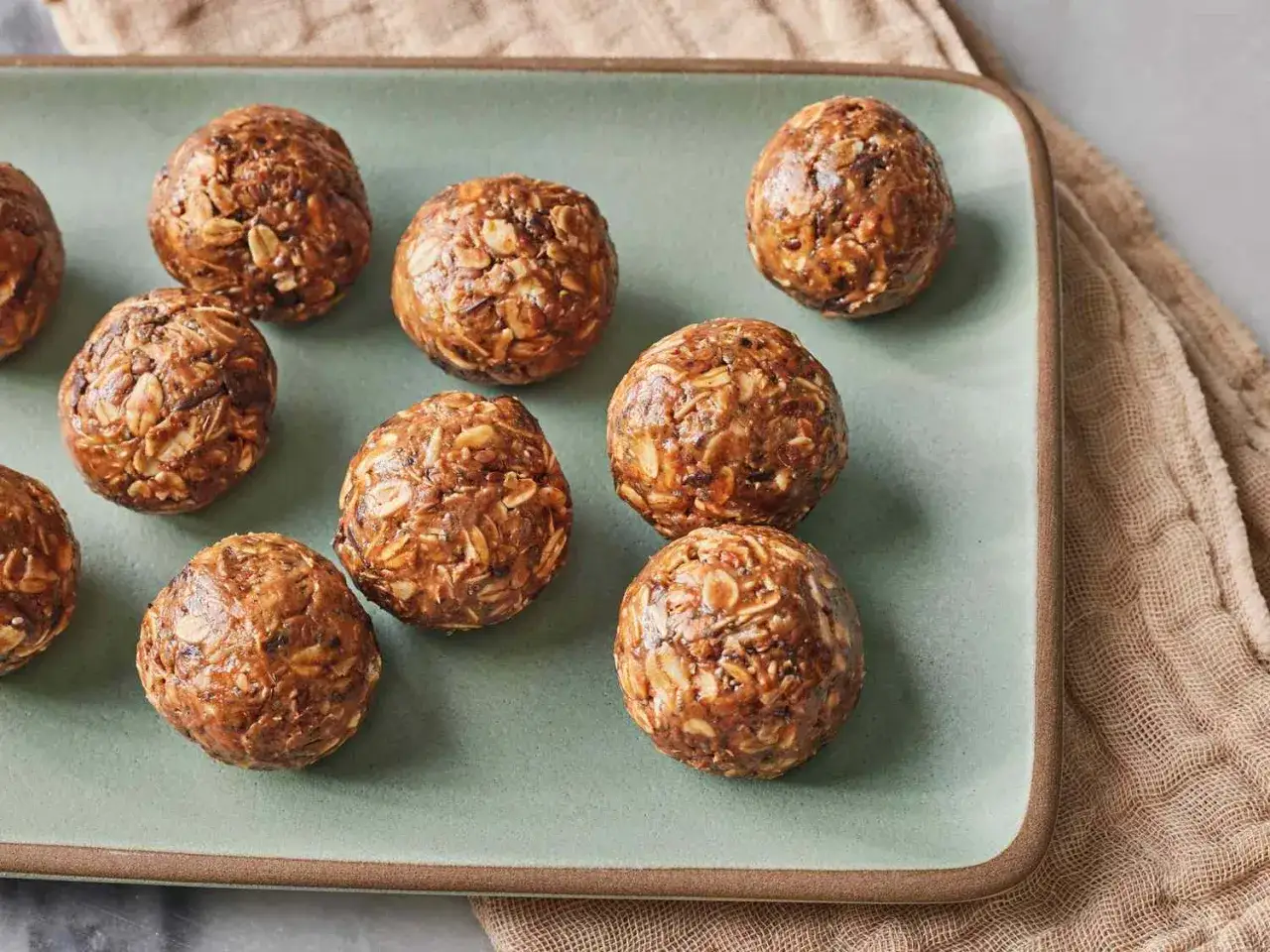 Flera protein chokladbollar ligger på ett fat. De ser goda och energigivande ut.