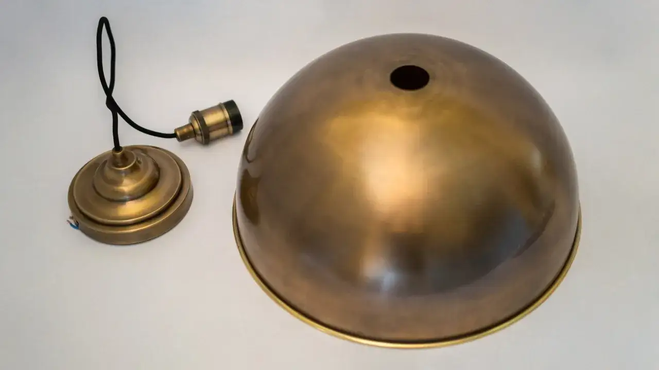 C&uacute;pula de l&aacute;mpara y base de bronce, listas para limpiar y restaurar su brillo.