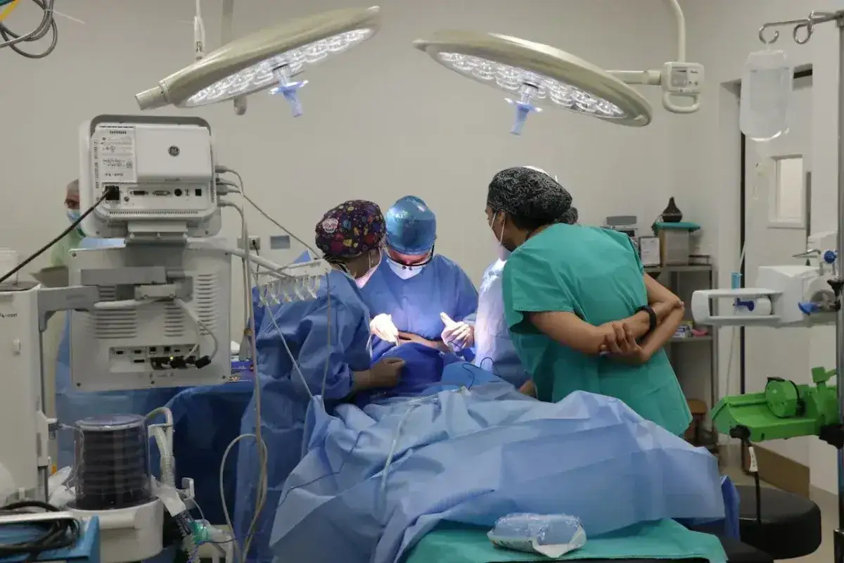 Zespół medyczny w sali operacyjnej. Pielęgniarka czuwa nad przygotowaniem pacjenta do zabiegu operacyjnego, wspierając chirurga.