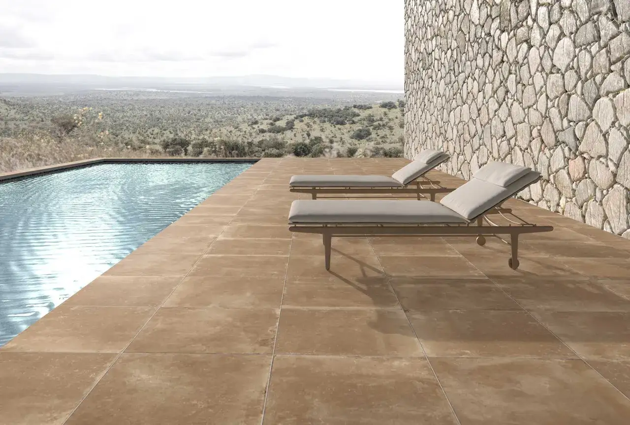 Terraza junto a piscina con tumbonas. El suelo antideslizante es el mejor suelo para exterior, seguro y elegante.