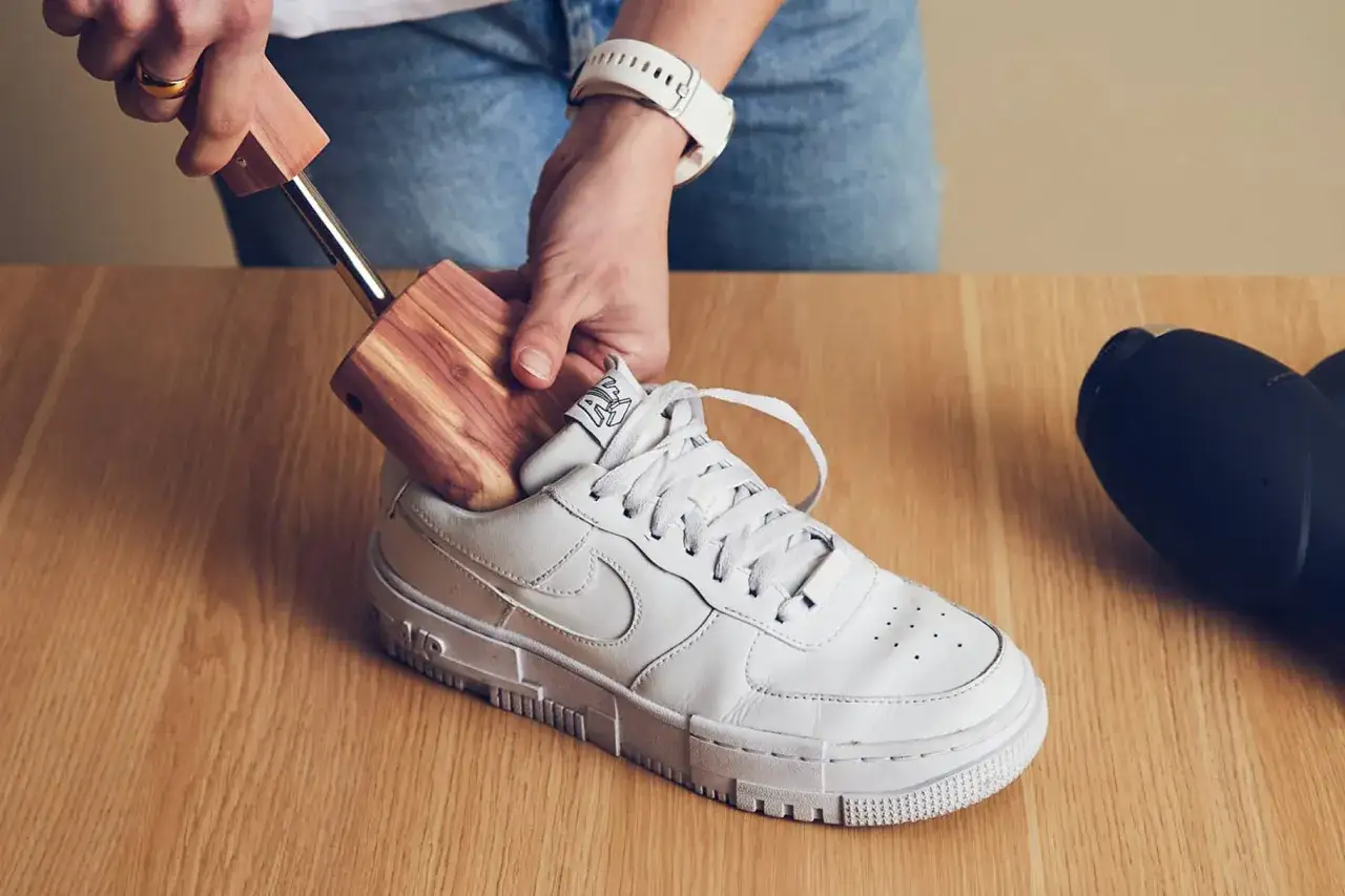 Jak usunąć zagięcia na butach? Włóż drewniany prawidło do białego sneakersa, aby przywrócić mu kształt.