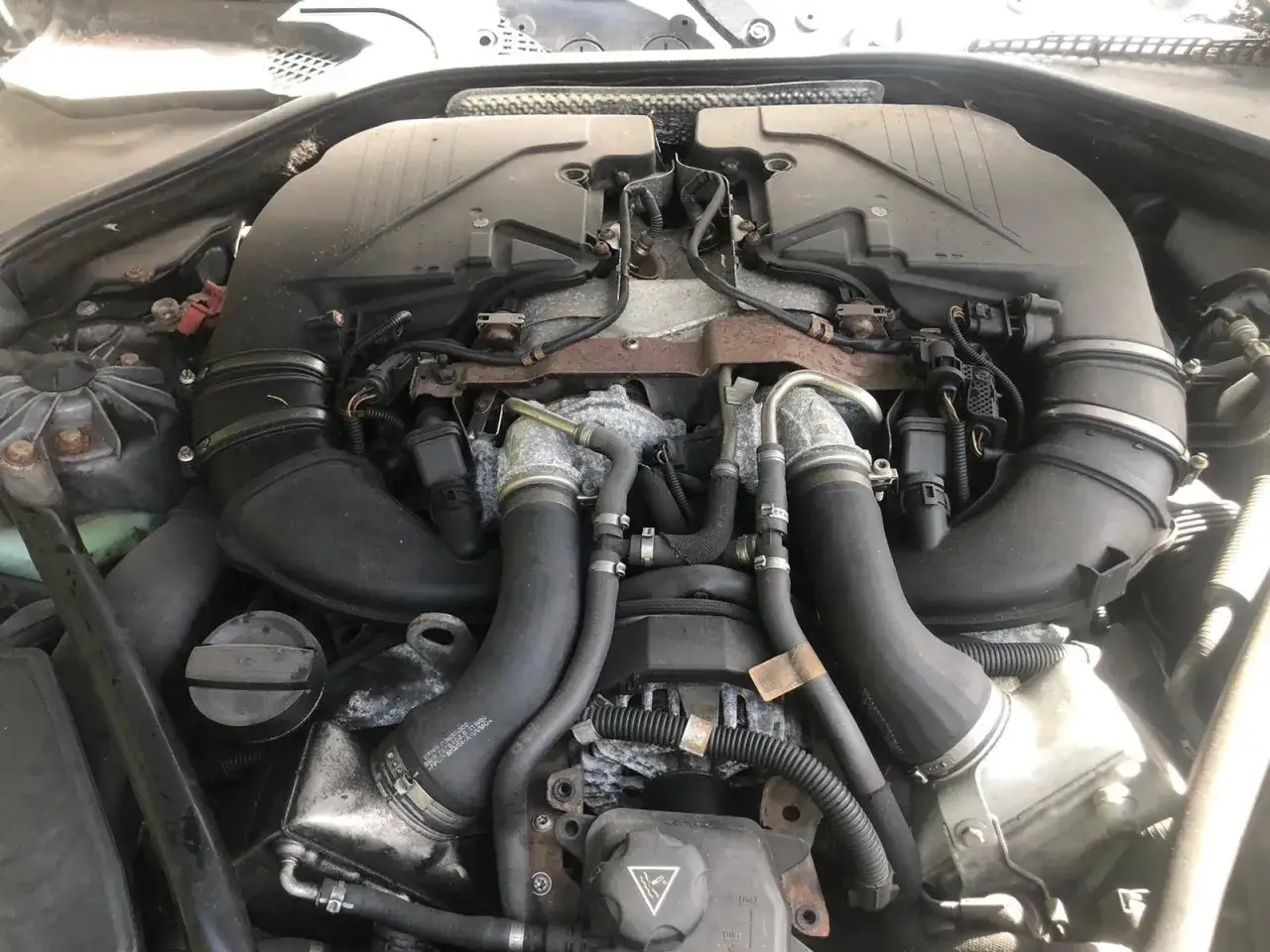 Silnik V12 BMW z widocznymi turbosprężarkami i przewodami dolotowymi.