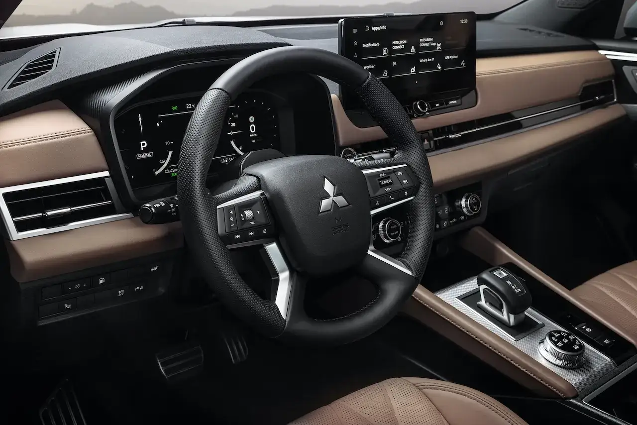 Wnętrze Mitsubishi Outlander PHEV: skórzana tapicerka, cyfrowe zegary i ekran multimediów.