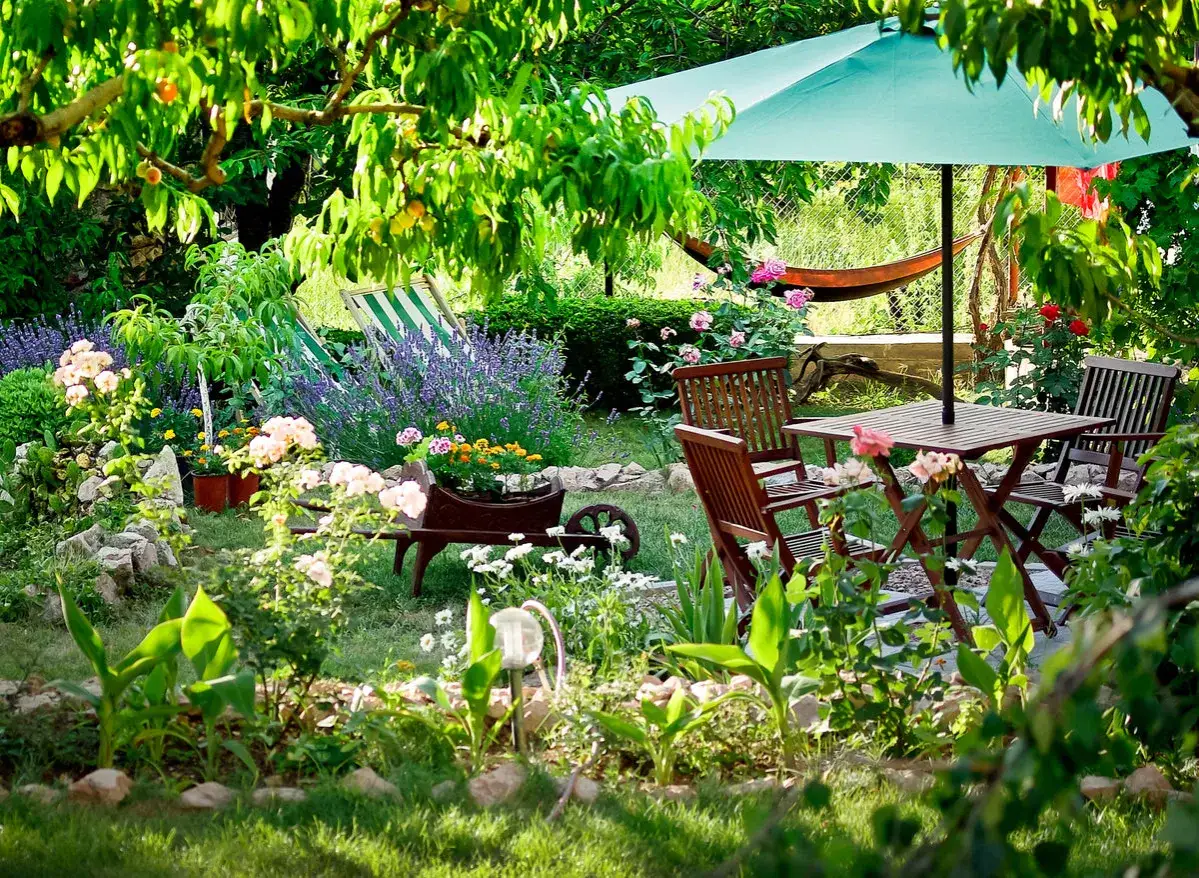 Ein idyllischer Garten, der zeigt, wie man mit wenig Geld einen schönen Rückzugsort gestalten kann: Lavendel, Rosen und eine gemütliche Sitzecke laden zum Verweilen ein.