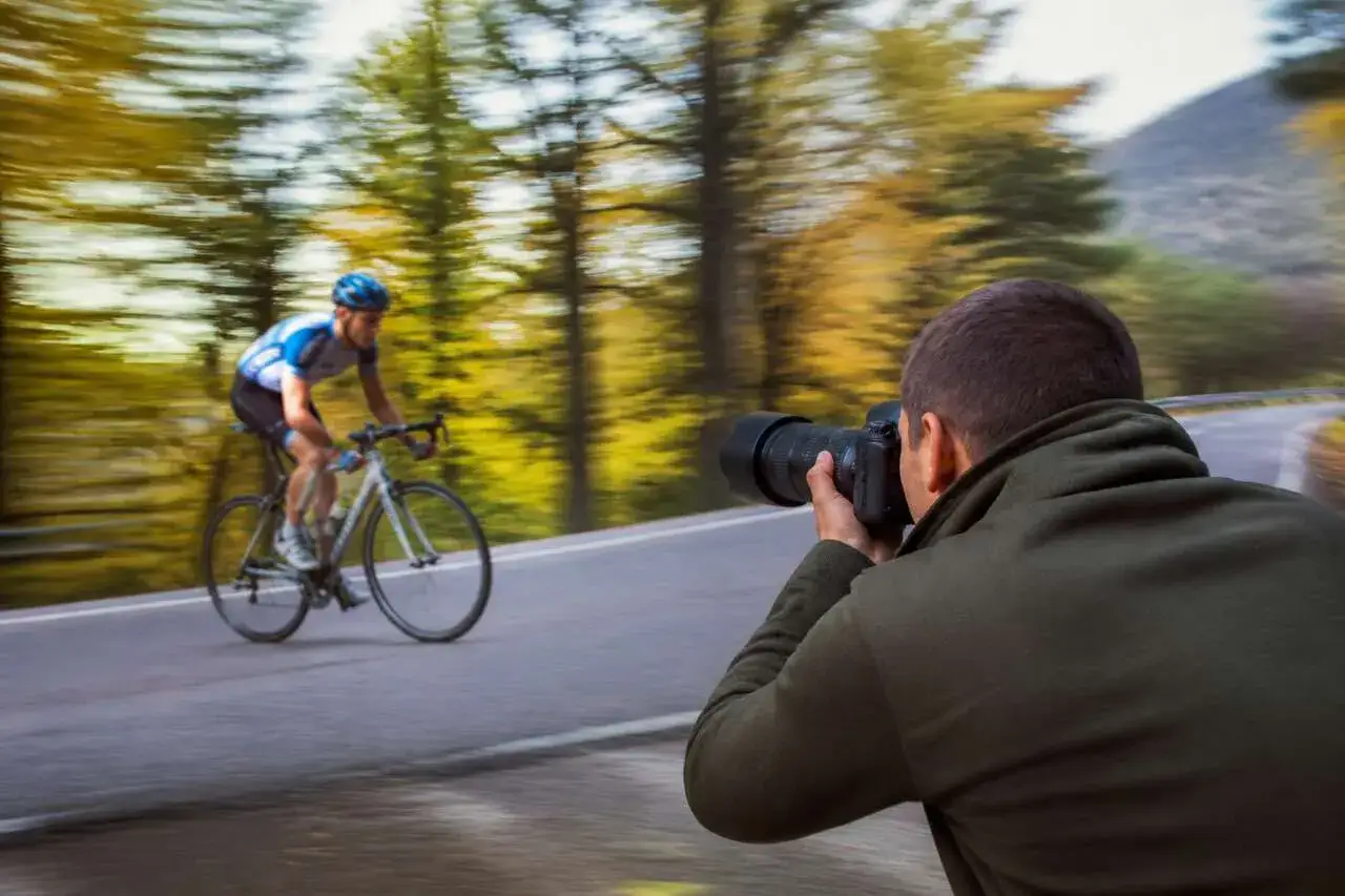 Un cycliste en plein effort, capturé par un photographe en mouvement. L'af c. de la scène est saisissant.