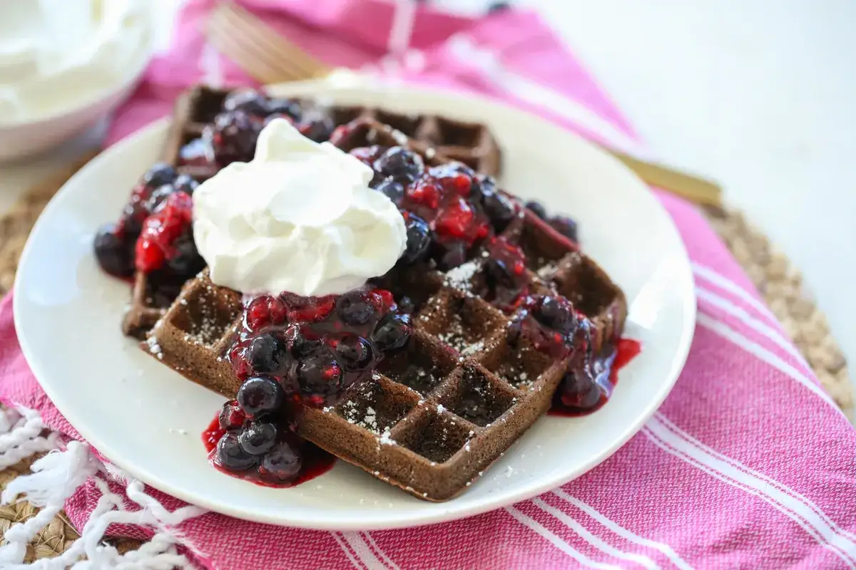Gaufre chocolat garnie de fruits rouges et de cr&egrave;me fouett&eacute;e, saupoudr&eacute;e de sucre glace. Un d&eacute;lice pour le petit-d&eacute;jeuner.