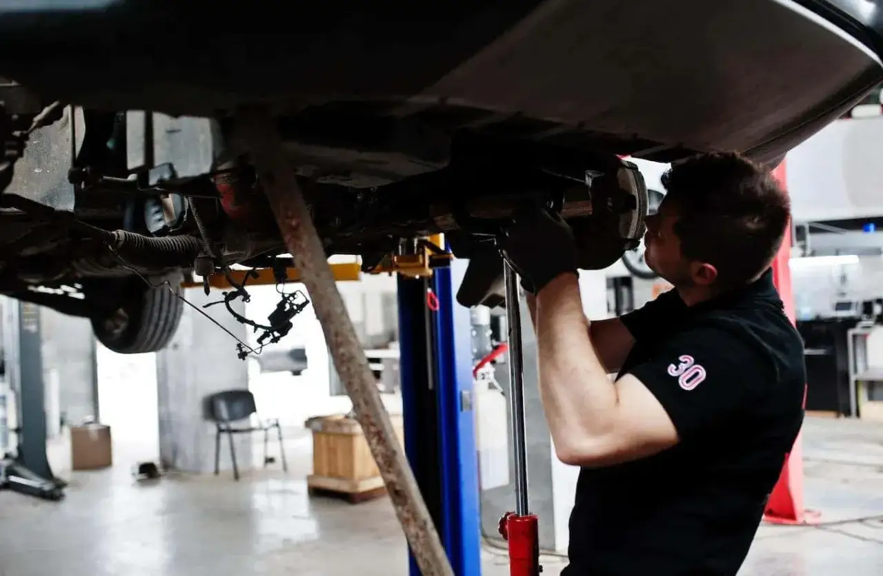 Mec&aacute;nico revisa el coche, investigando cuanto dura una caja de cambios manual.