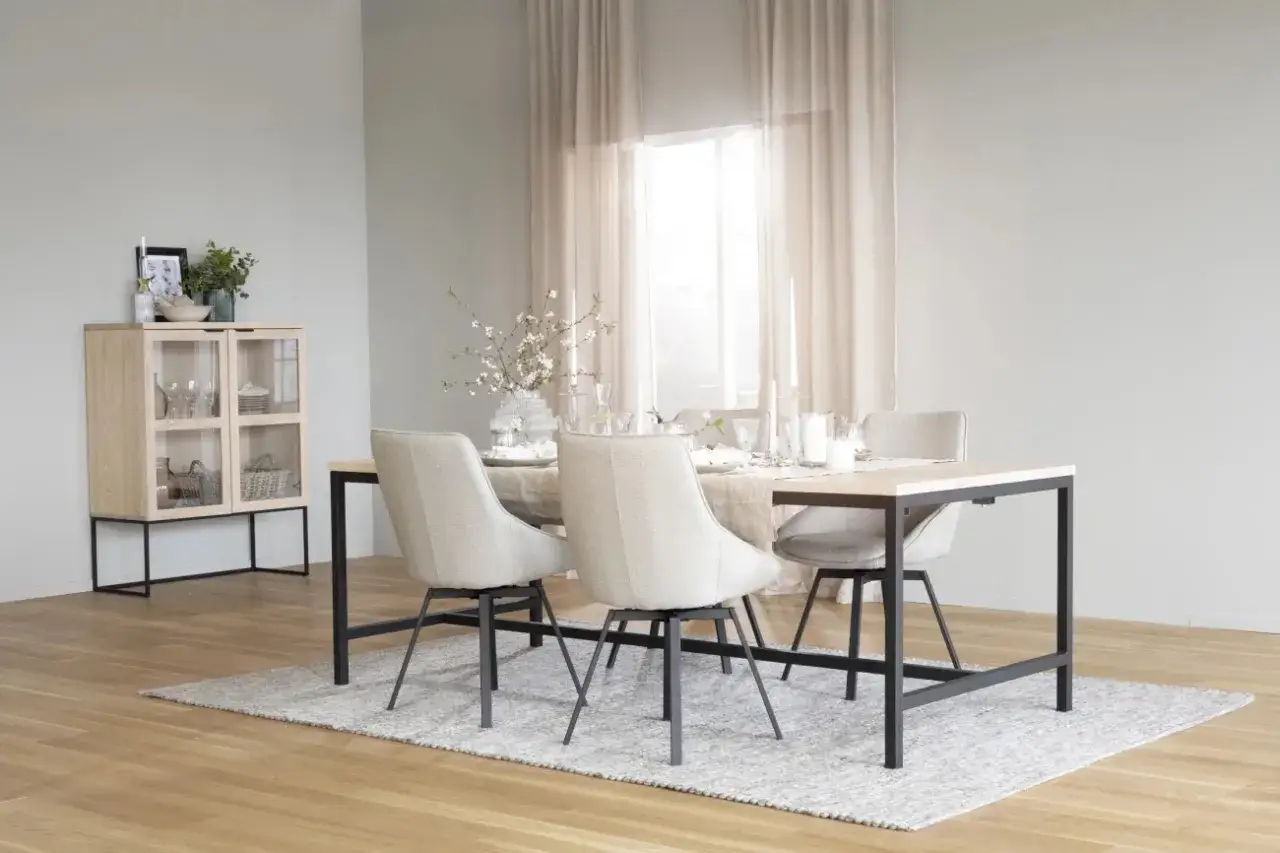 Ett ljust och luftigt matrum med fokus p&aring; nordisk design. Ett tr&auml;sk&aring;p med glasd&ouml;rrar st&aring;r till v&auml;nster, medan ett rektangul&auml;rt matbord med fyra stolar utg&ouml;r rummets mittpunkt.