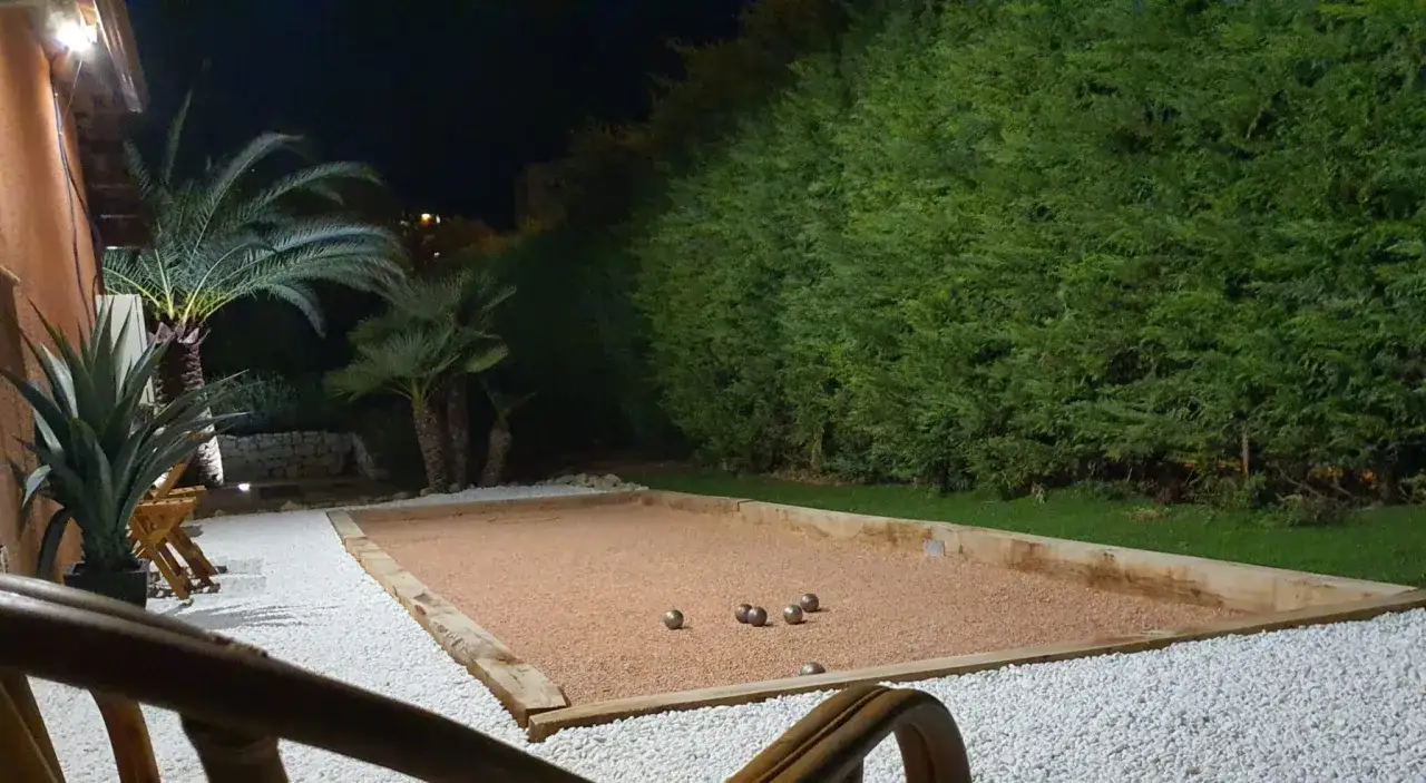 Un terrain de p&eacute;tanque illumin&eacute; la nuit, avec des boules pr&ecirc;tes pour une partie. Une belle id&eacute;e pour des soir&eacute;es conviviales.