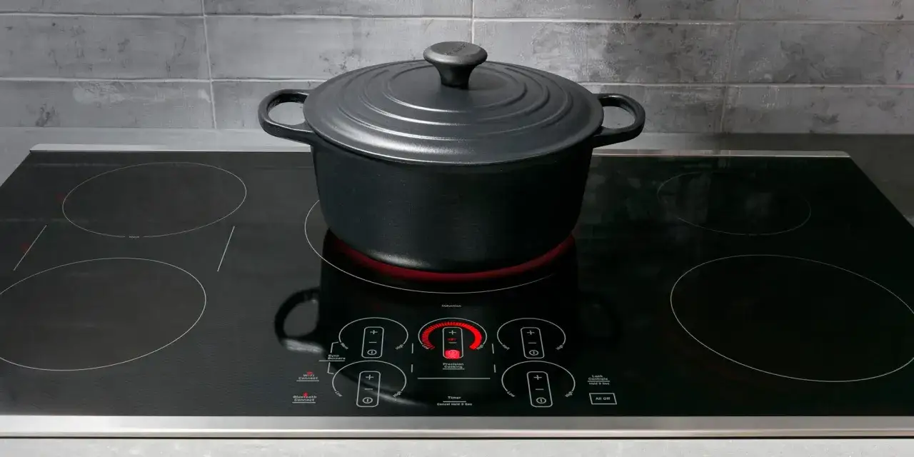 Olla negra sobre placa de inducción moderna. El control de