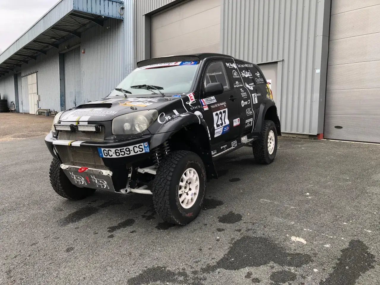 Czarny Toyota RAV4 przygotowany do rajdów off-road, z licznymi naklejkami sponsorów i numerem 237.