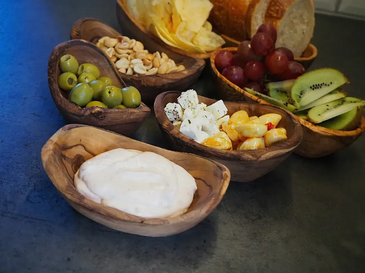 En h&auml;rlig upps&auml;ttning av tilltugg i tr&auml;sk&aring;lar: oliver, n&ouml;tter, ost, vitl&ouml;k, kiwi, vindruvor, chips och br&ouml;d. En perfekt rotfrukter lista f&ouml;r en fest!