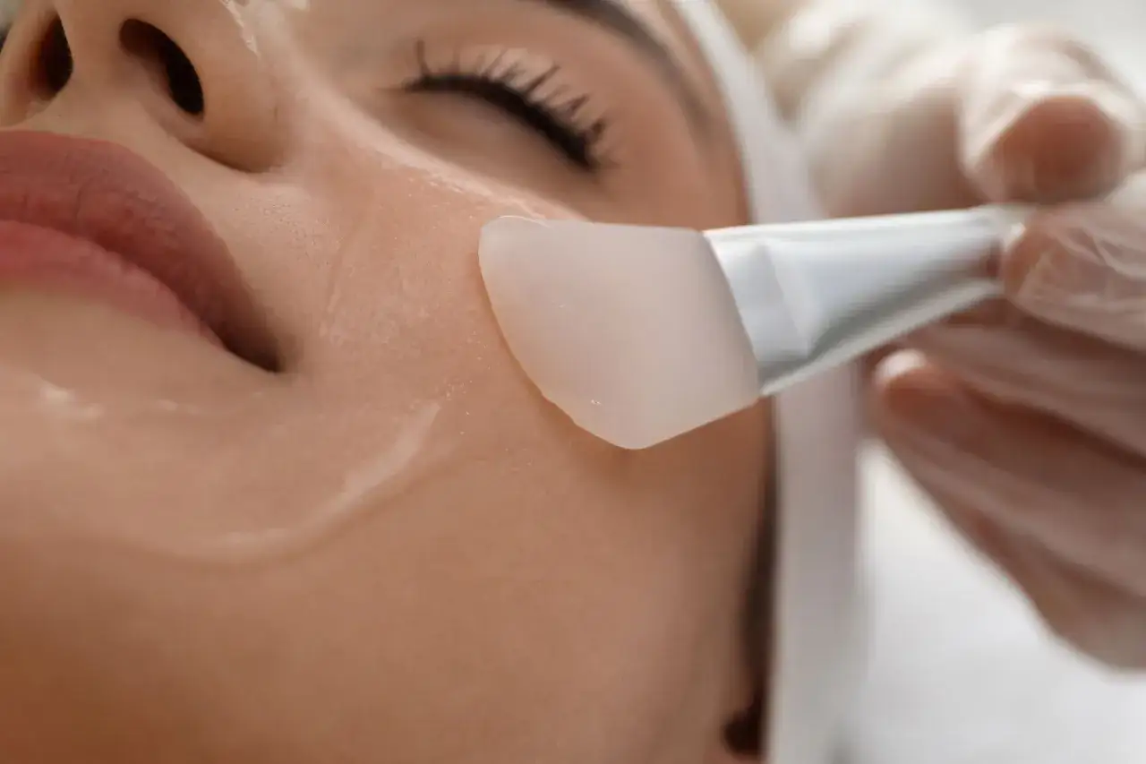 Applicazione di un gel trasparente sul viso con un pennello, parte di un trattamento **oxygen peel Filorga modo d'uso**.