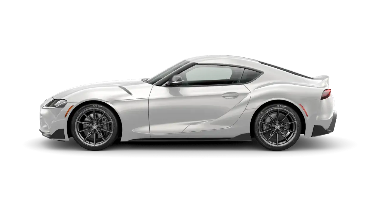 Biała Toyota GR Supra z ciemnymi felgami, prezentująca sportowy profil i aerodynamiczne linie.