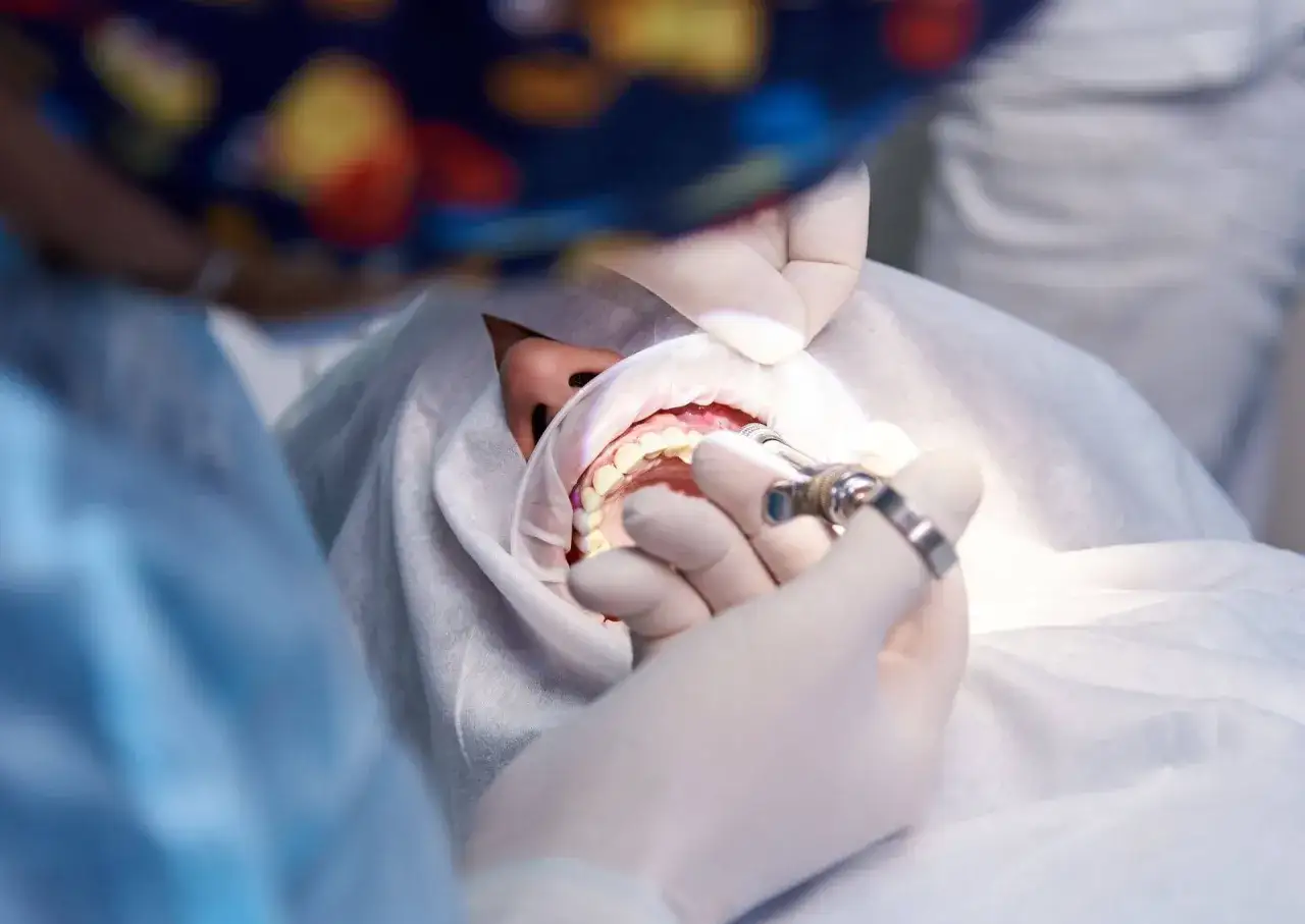 Dentysta podaje znieczulenie pacjentowi z przodozgryzem, przygotowując się do leczenia.