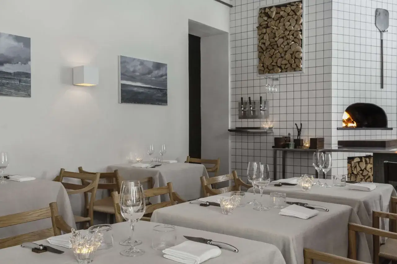 Elegant dukade bord p&aring; en michelin restaurang i Stockholm. Vedeldad ugn i bakgrunden.