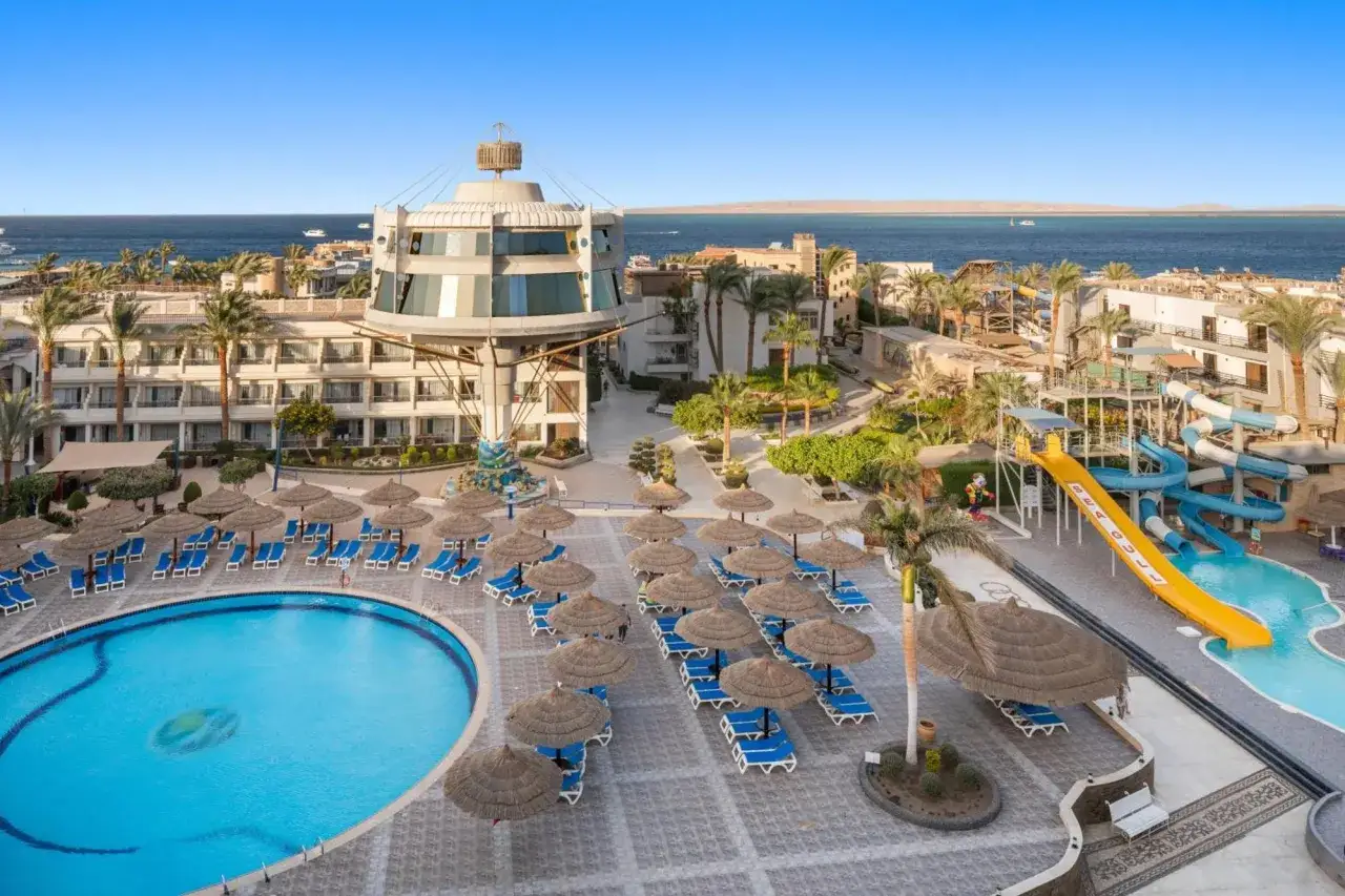Widok na basen, zjeżdżalnie i morze w kurorcie **sea gull beach resort (Hurghada)**. Palmy i leżaki zapraszają do relaksu.
