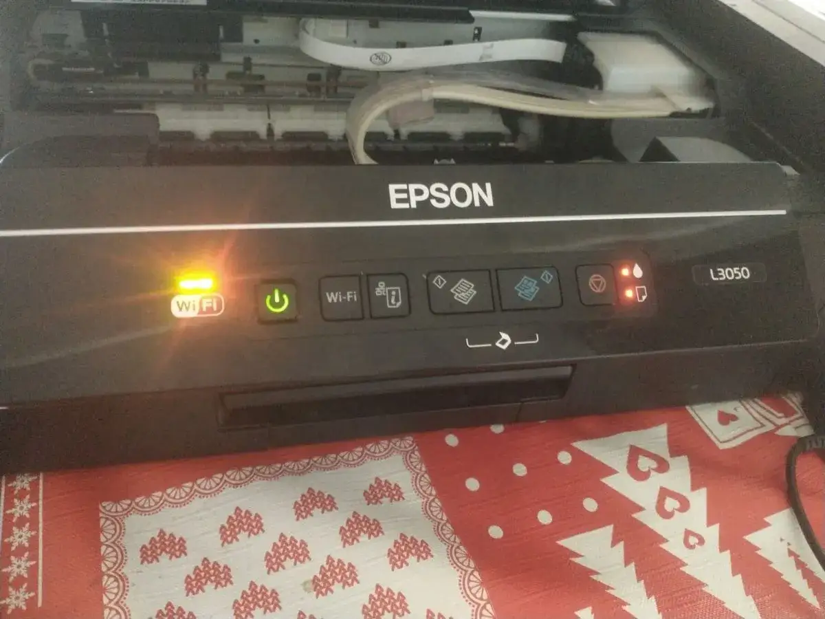 Drukarka Epson L3050 miga i nie chce drukować. Pomarańczowa lampka Wi-Fi świeci, a wskaźniki tuszu palą się na czerwono.