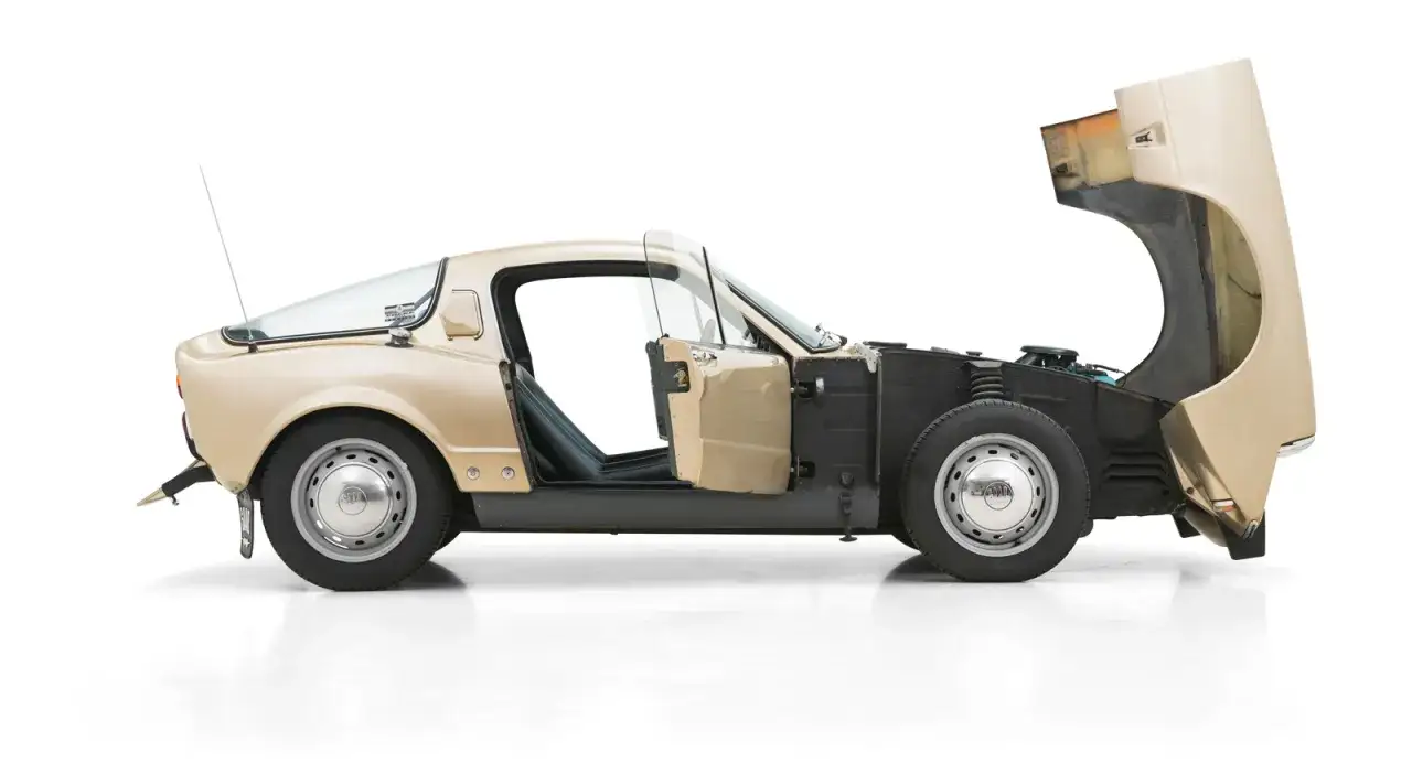 En beige Saab Sonett 2 med öppen dörr och motorhuv.