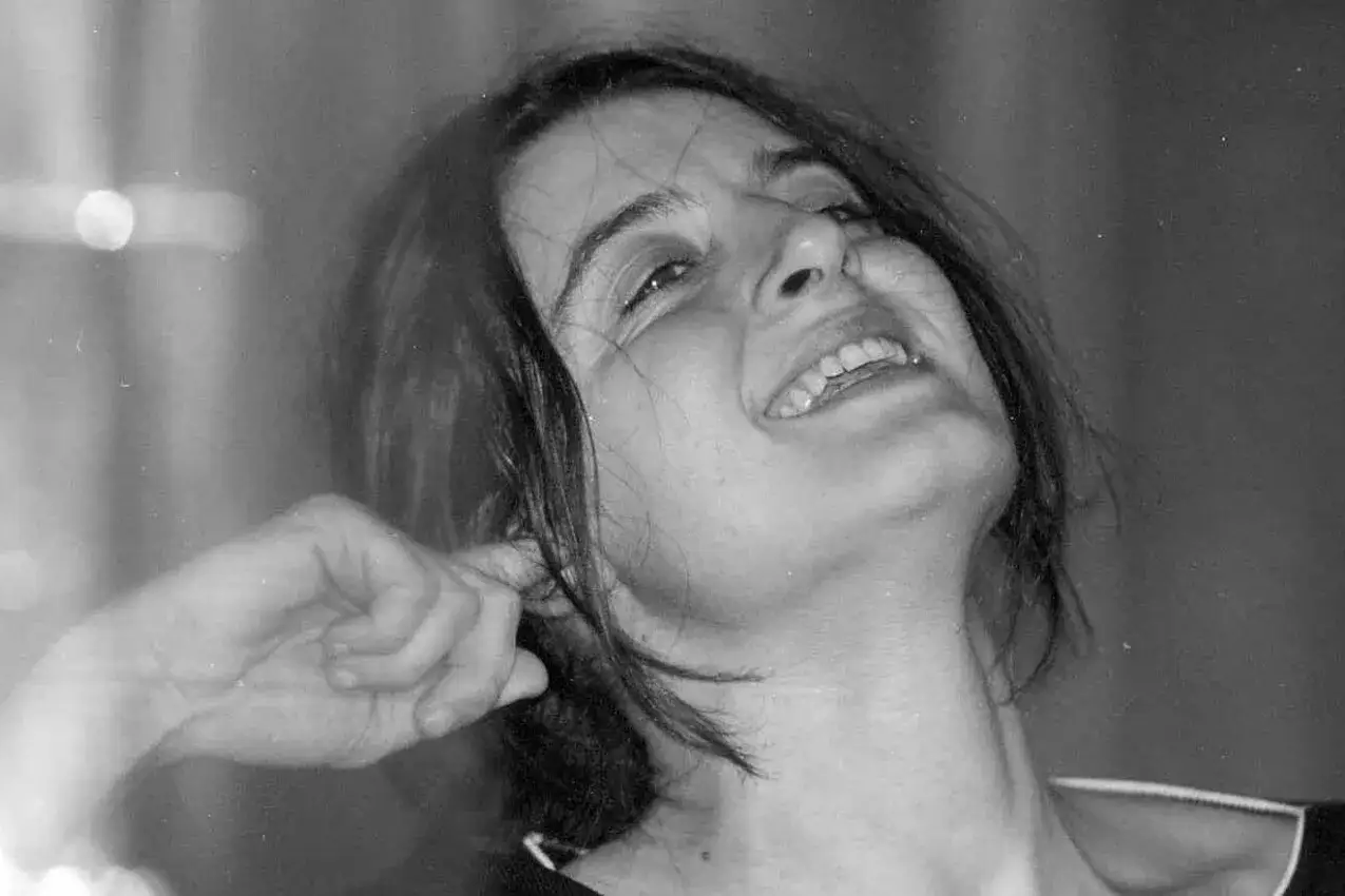 Un sorriso radioso, un gesto spontaneo che cattura l'essenza de l'arte della gioia riassunto. La luce illumina il suo volto, mentre un dito sfiora l'orecchio, quasi a voler ascoltare la melodia della felicità.