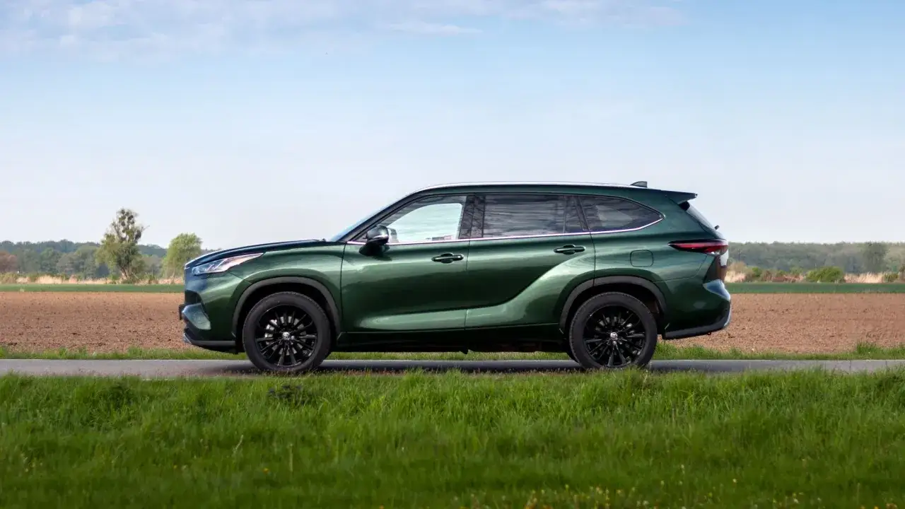 Zielony Toyota Highlander na tle pól i nieba. Zastanawiasz się nad jego **spalanie**?