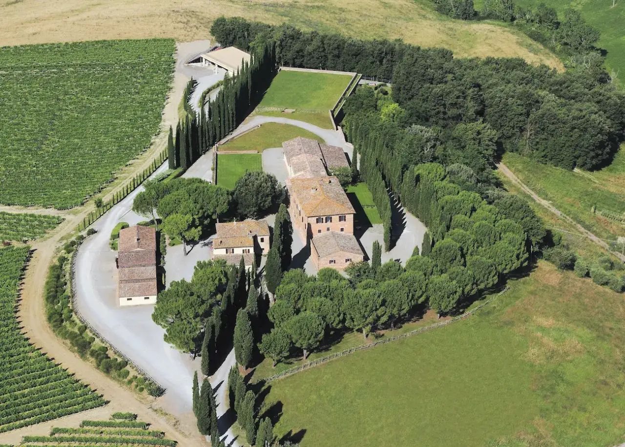Vista aerea della tenuta Altesino, con vigneti, cipressi e casali in pietra.
