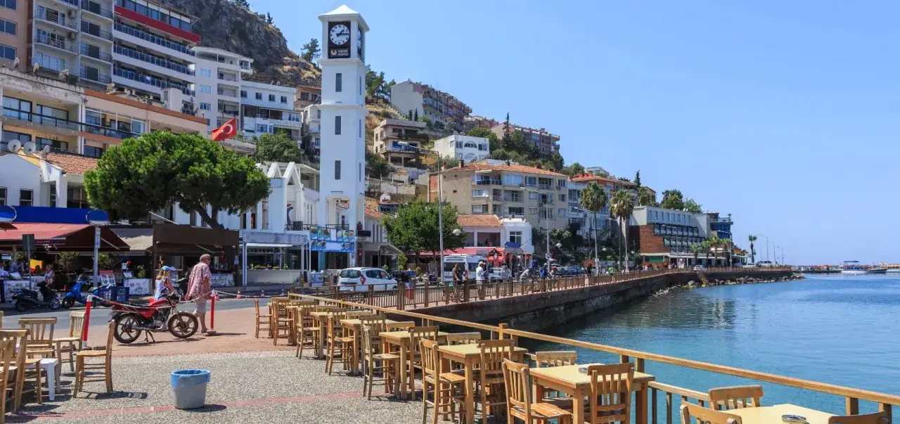 Kusadasi, Turchia: la torre dell'orologio domina la vivace passeggiata sul lungomare, con ristoranti e hotel che si affacciano sul mare.