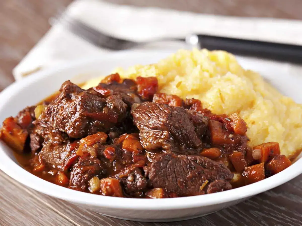 Un plat de daube de sanglier sans marinade, mijoté avec des légumes, servi avec une purée de maïs crémeuse. Un délice !