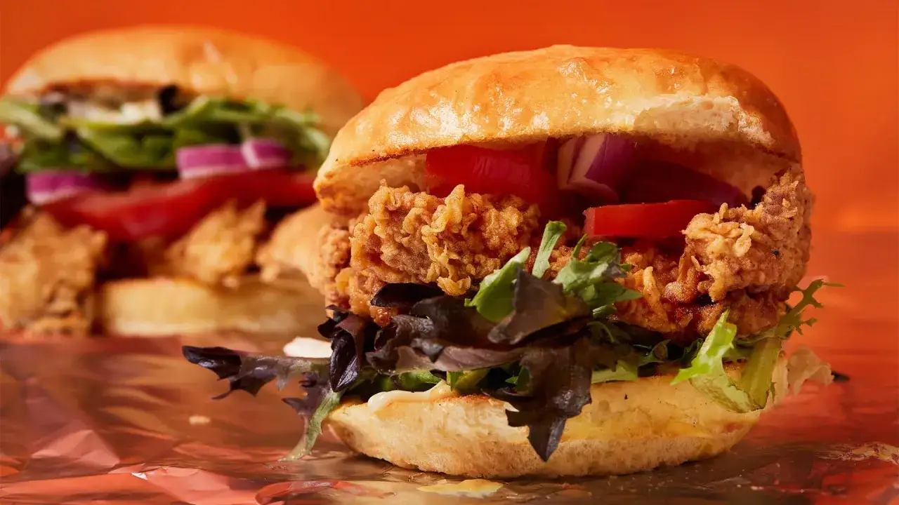 Tv&aring; saftiga hamburgare med krispig kyckling, tomat, l&ouml;k och sallad. En perfekt hamburgare smet f&ouml;r en hungrig mage.