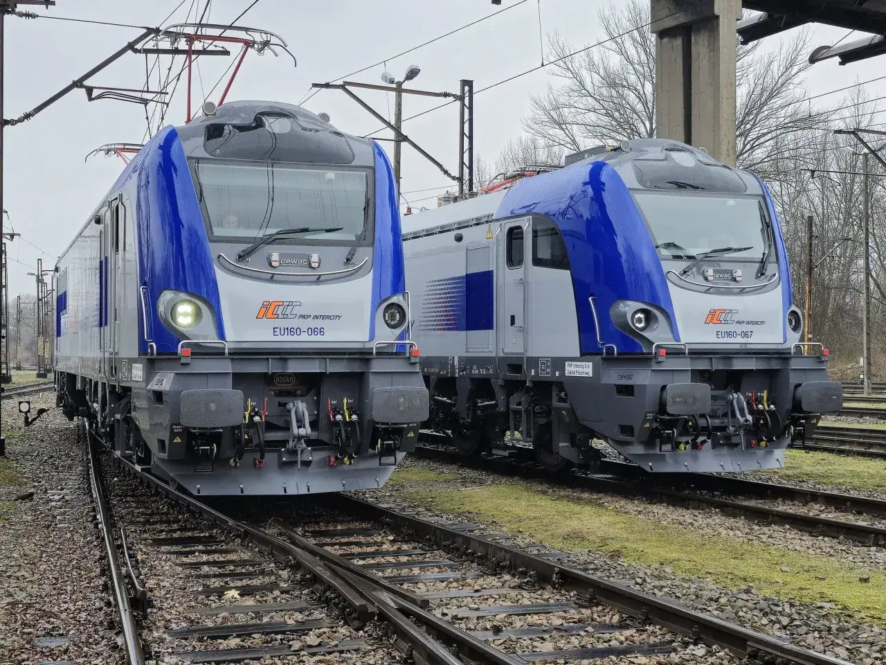 Dwie nowoczesne lokomotywy Newag EU160 PKP Intercity stoją obok siebie na torach.