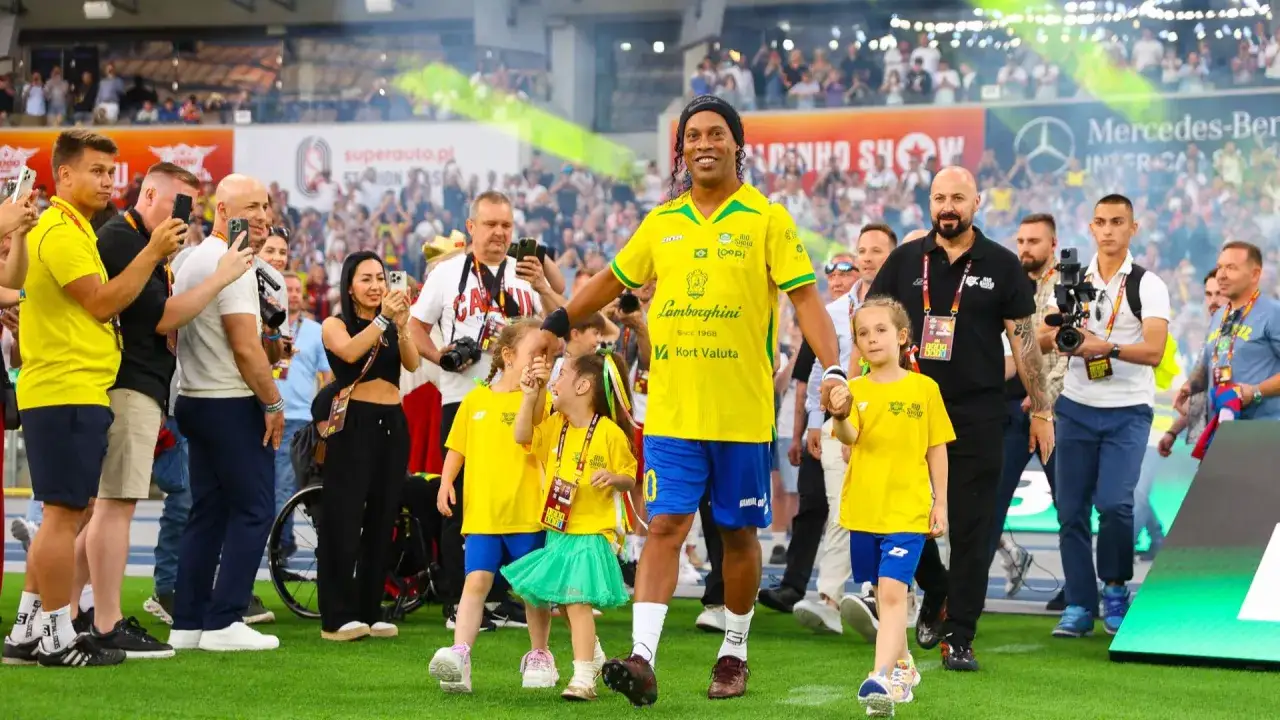 Ronaldinho, żyje i ma się dobrze, spaceruje po boisku w żółtej koszulce z napisem 