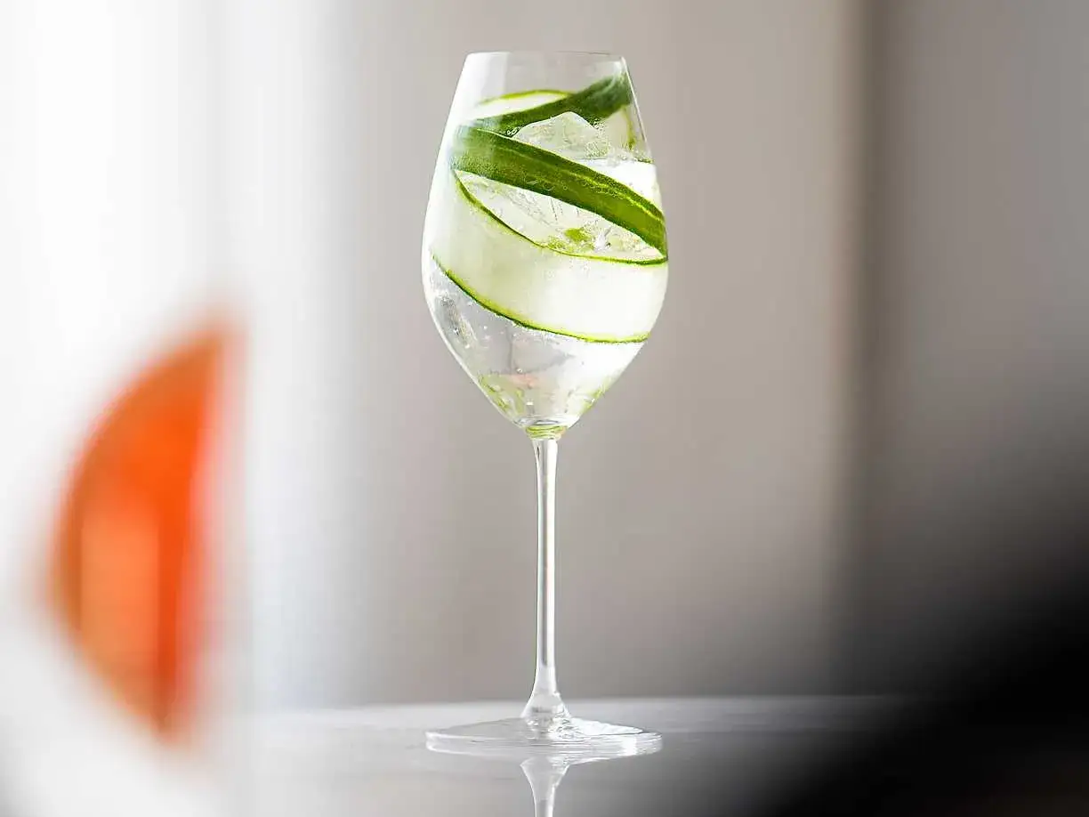 Ett glas med en enkel drink, fylld med is och gurkskivor. Perfekt f&ouml;r en svalkande stund.