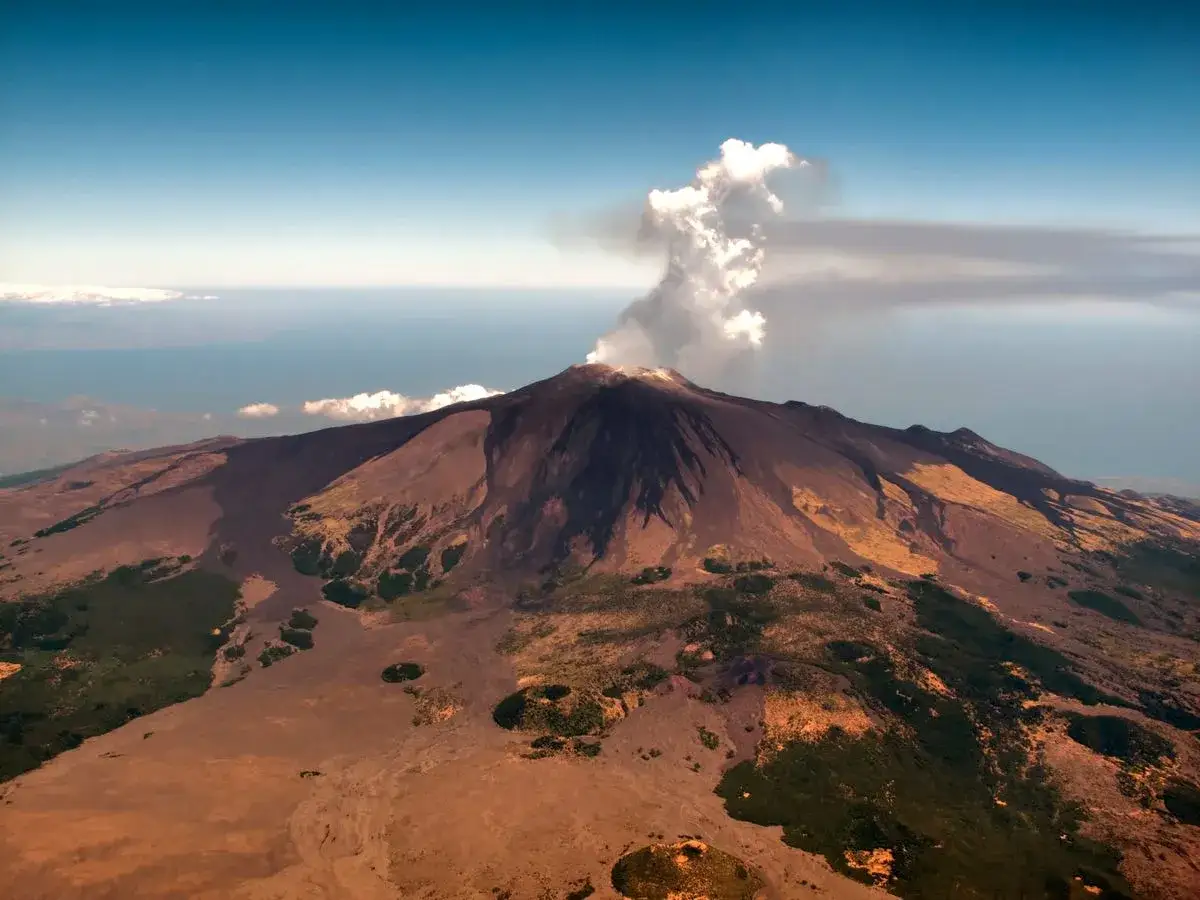 Etna fumante, un'avventura di randonn&eacute;e etna sans guide. Paesaggio vulcanico mozzafiato sotto un cielo azzurro.