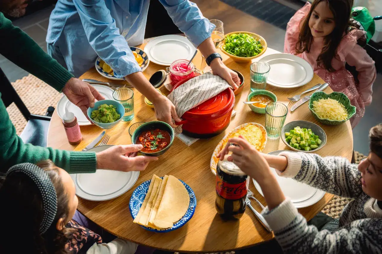 Familjen samlas runt bordet för att äta tacos. Guacamole, salsa och ost står framdukat. Vad kan man göra mer än att njuta av god mat och varandras sällskap?