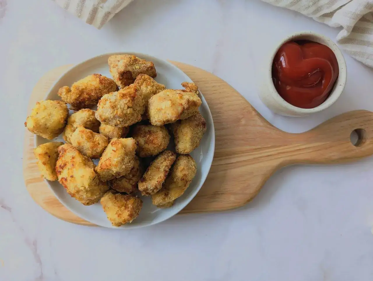 Chrupiące nuggetsy z airfryer na talerzu, obok miseczka ketchupu. Idealna przekąska!