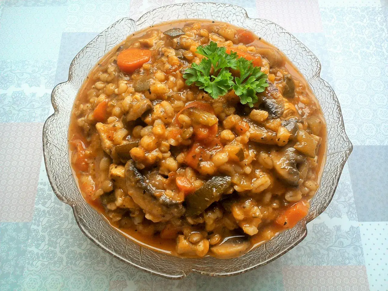 Pyszny bigos z cukinii z kaszą i warzywami, udekorowany natką pietruszki.