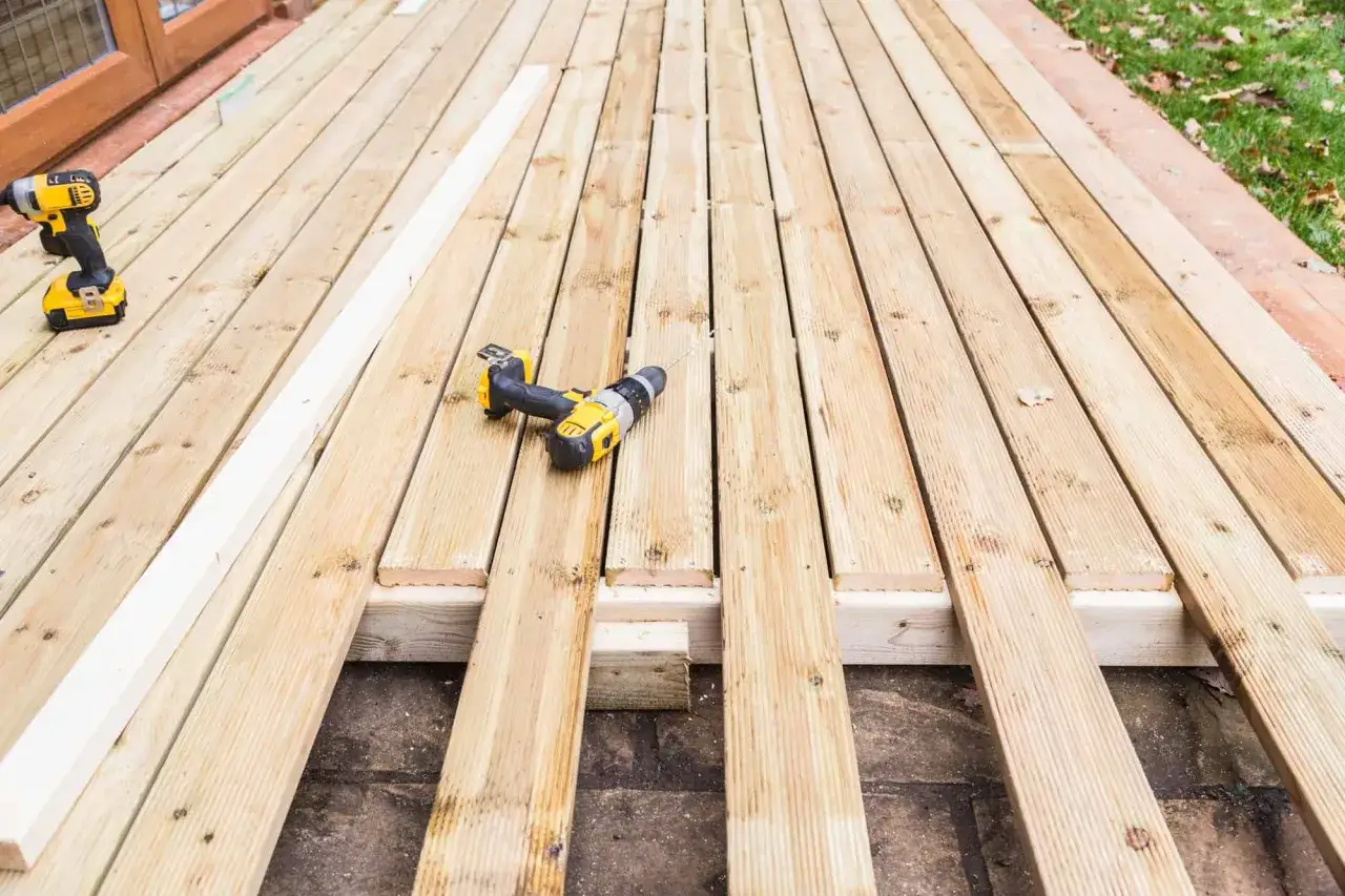 Construcción de terraza con madera natural, ideal para exterior. Taladros y listones listos para el montaje.