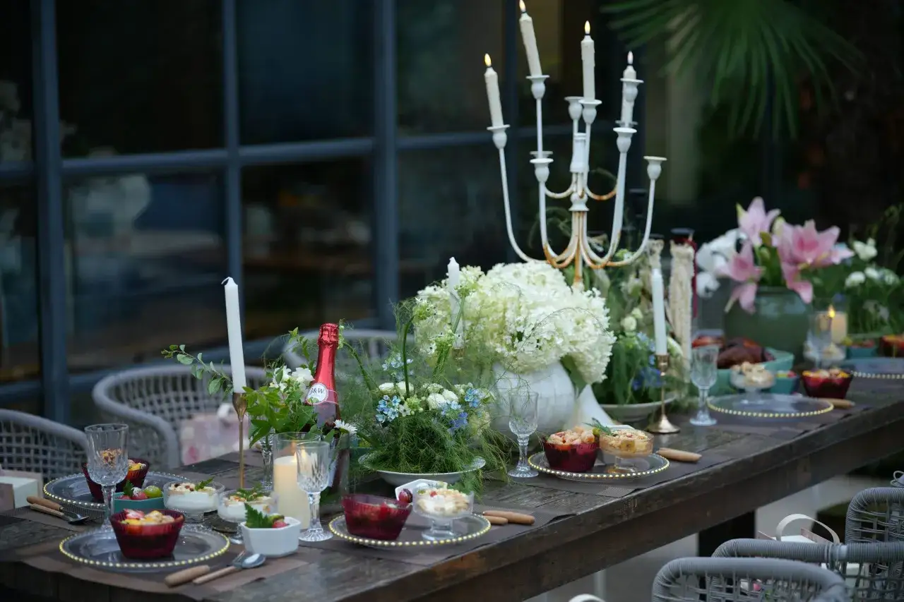 Elegante mesa puesta con velas y flores, lista para una cena rom&aacute;ntica.