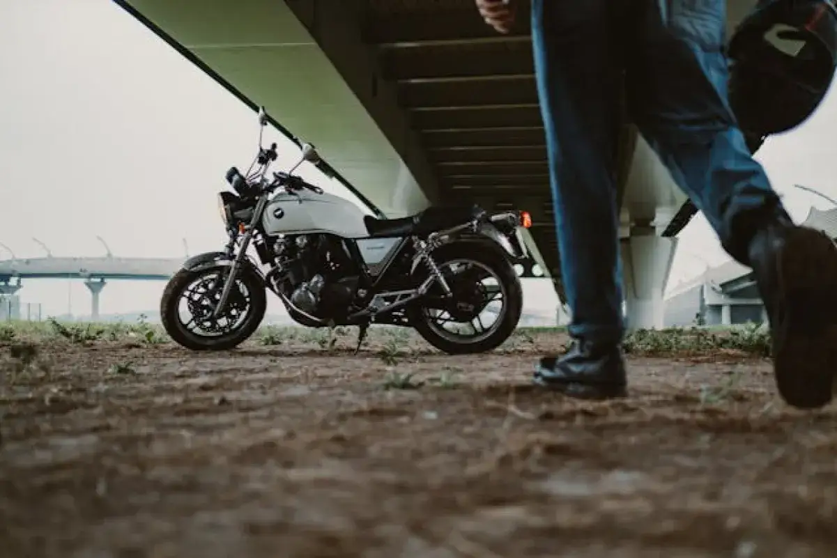 Biały motocykl i kask &ndash; to obowiązkowe wyposażenie motocykla, gotowe do drogi pod mostem.