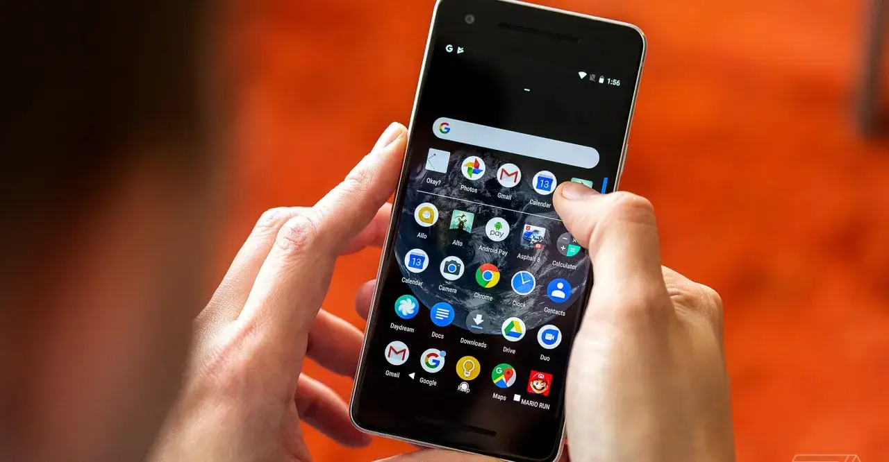 Main d'une personne manipulant un smartphone Android, montrant comment organiser son t&eacute;l&eacute;phone avec des ic&ocirc;nes d'applications.