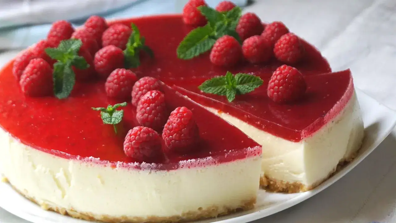 Deliciosa tarta de queso sin horno, cubierta con coulis de frambuesa y frambuesas frescas. &iexcl;Un postre perfecto!